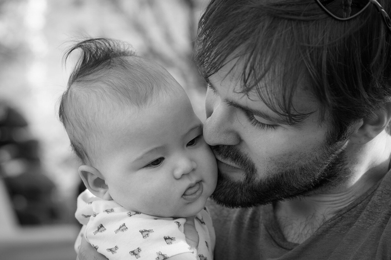 A father tenderly comforting his child during a moment of distress, highlighting emotional connection in modern parenting