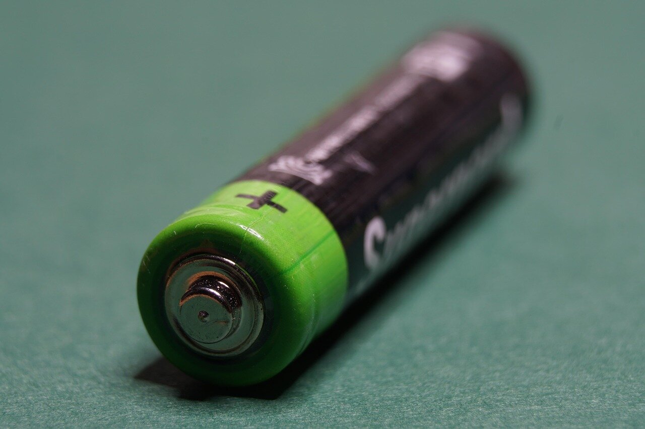 A bustling factory floor where advanced battery manufacturing processes are taking place, showcasing the evolution of technology in energy storage