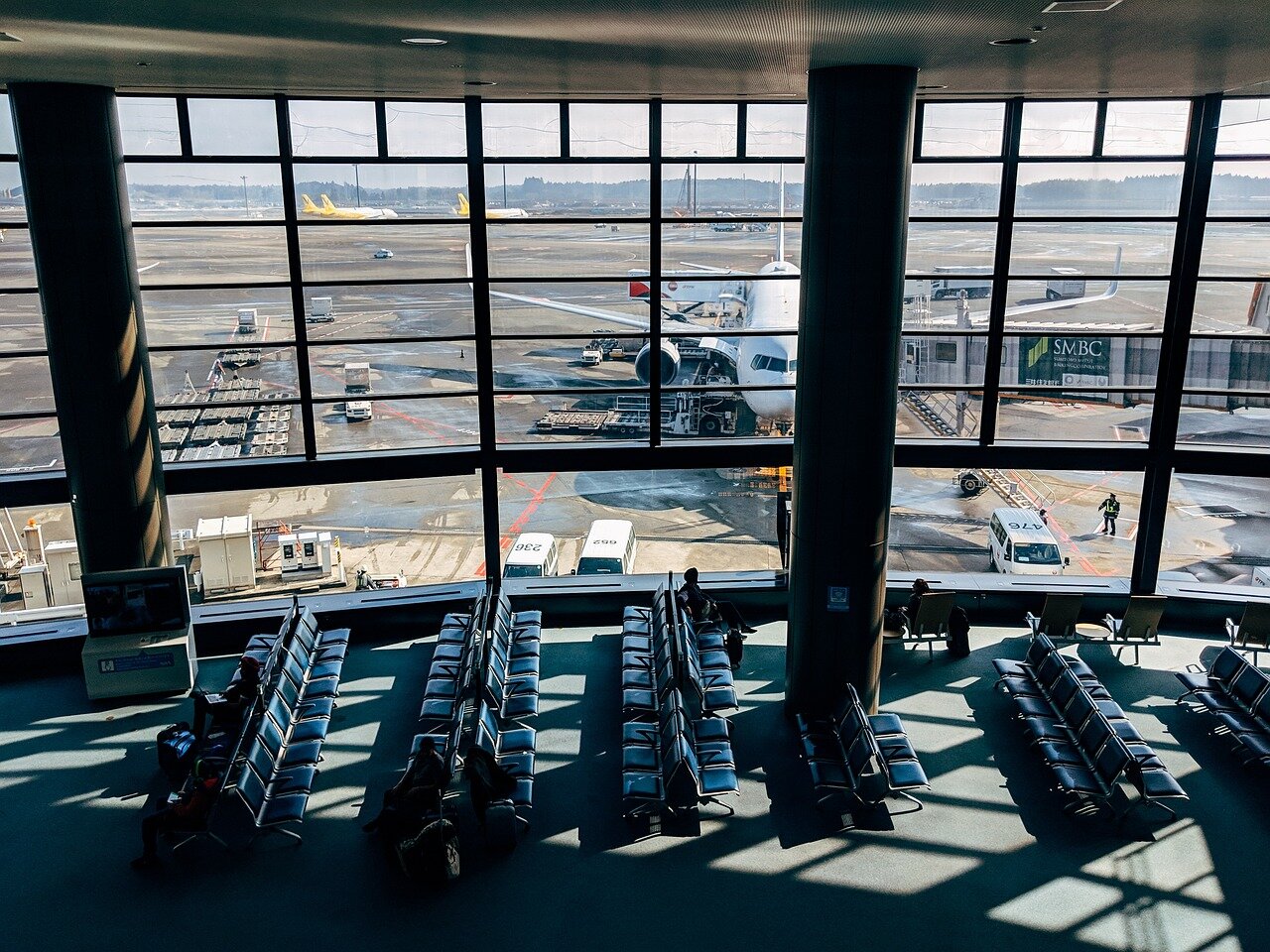 A crowded airport terminal filled with frustrated travelers waiting for updates on their delayed flights during the 2022 holiday season