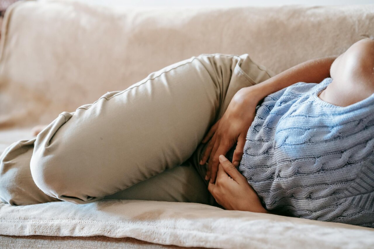 A woman sitting quietly, reflecting on the emotional toll of living with adenomyosis, showcasing the often invisible struggles faced daily