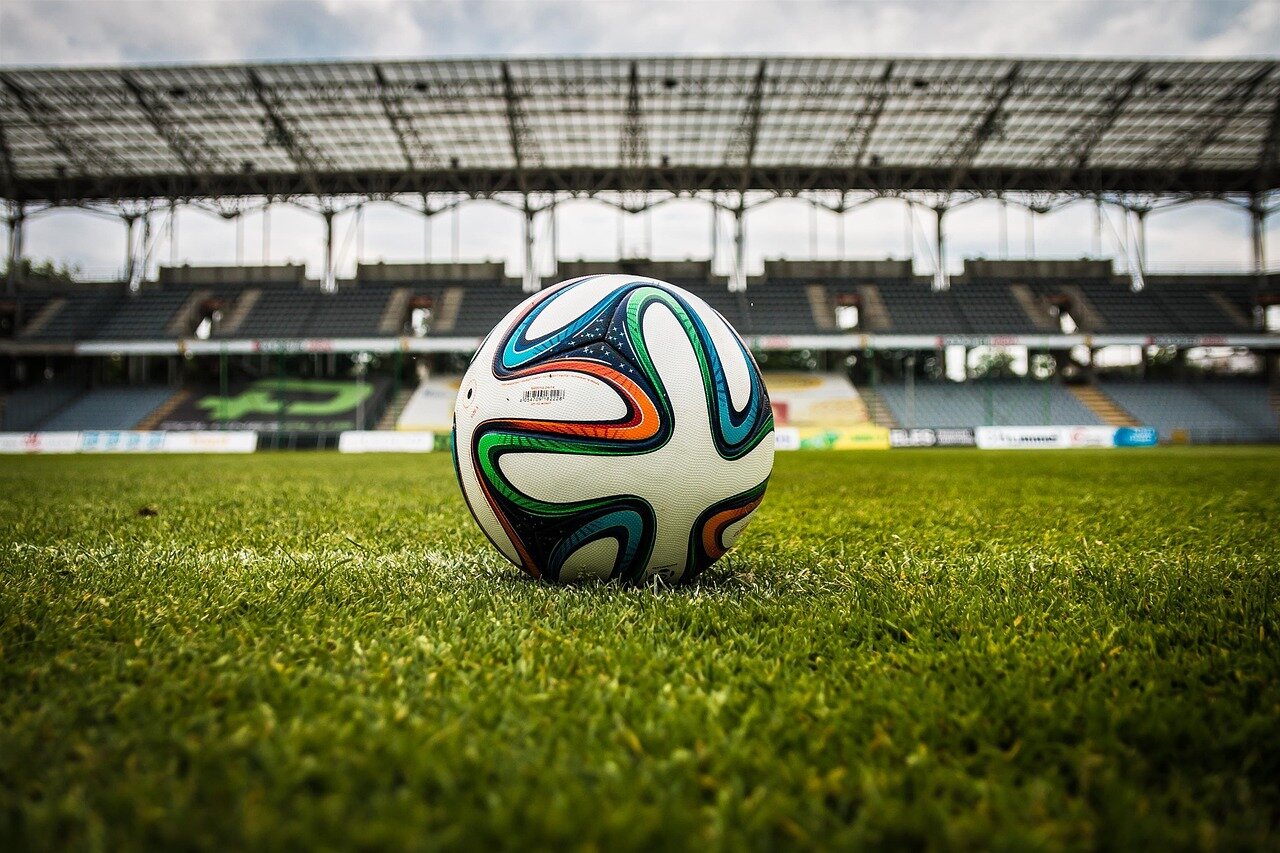 A community gathering where local fans come together to watch a football match, highlighting the sport's role in fostering connection and pride