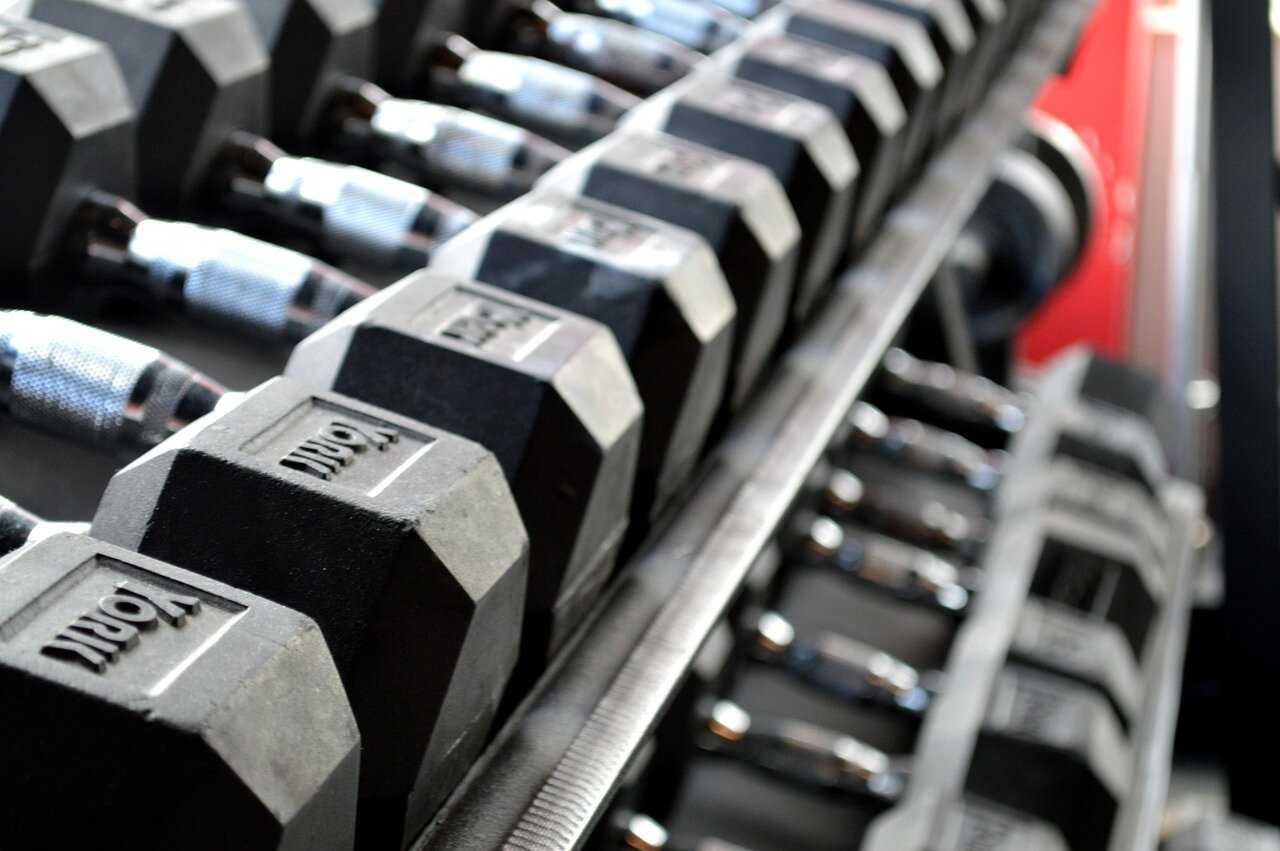 Engineers and scientists collaborate at a workspace filled with advanced gym equipment prototypes designed for astronauts, showcasing innovative fitness solutions tailored for microgravity environments.