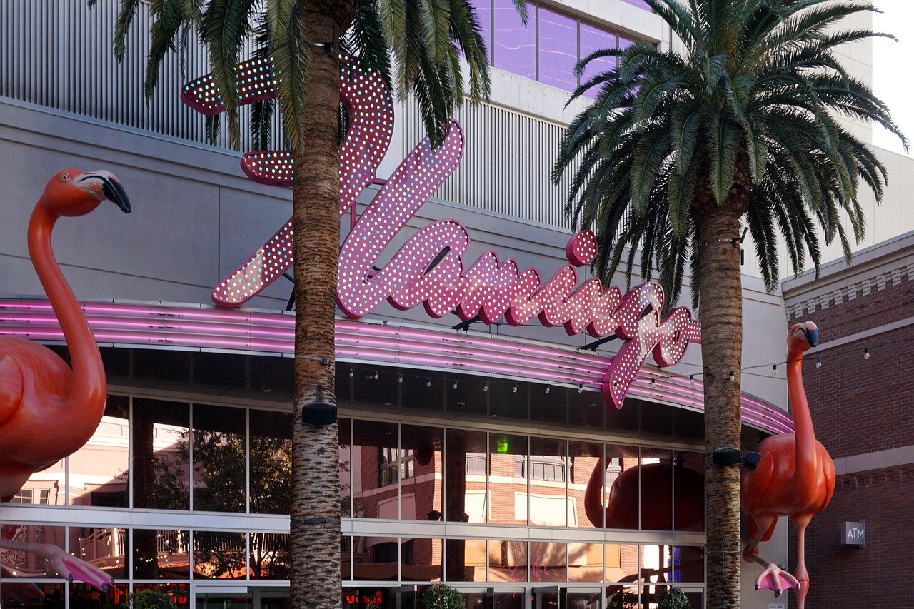Athletes gather at a bustling Las Vegas sports betting venue, studying odds and placing wagers as excitement fills the air.