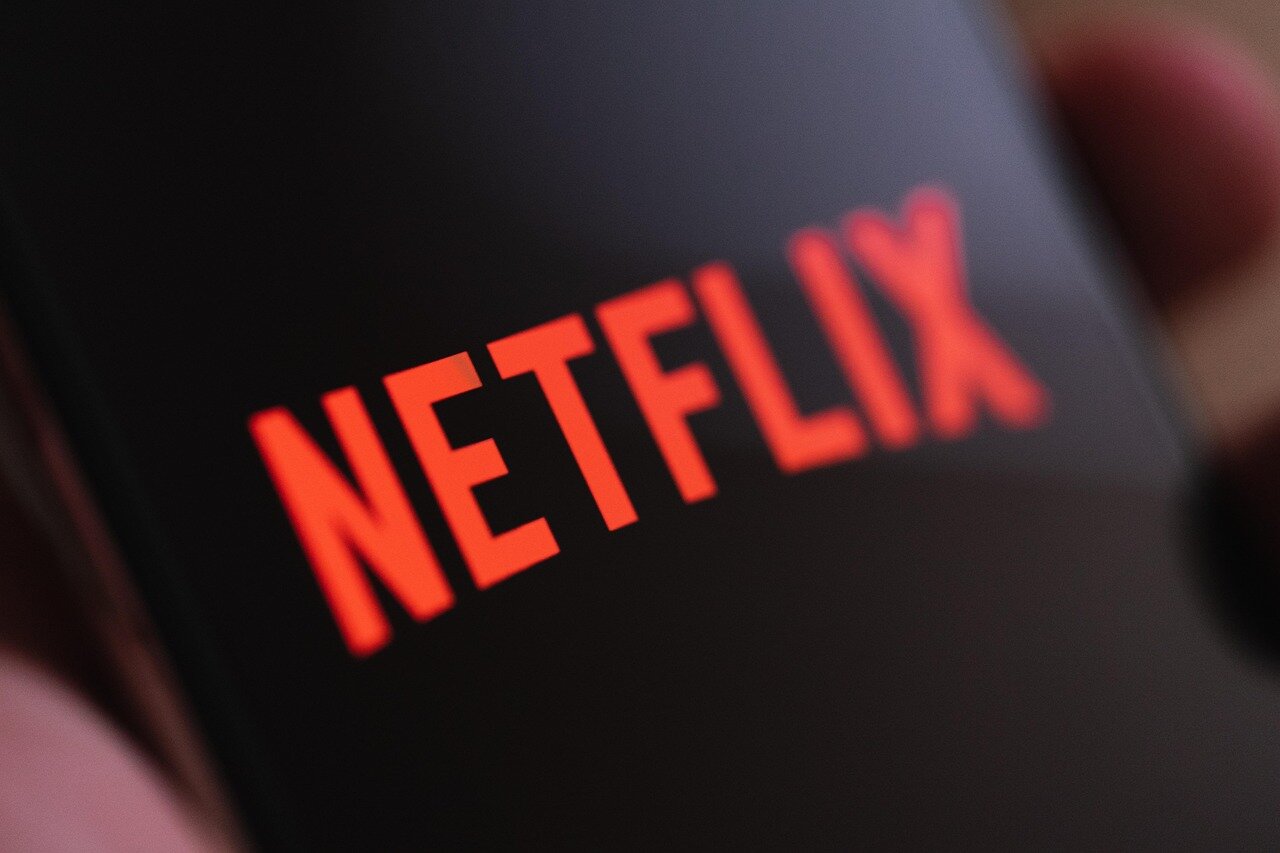 A closeup of hands signing the union contract, symbolizing a historic agreement between Netflix and The Animation Guild for better working conditions