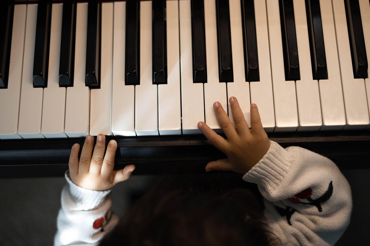 A young competitor intensely focuses on the screen during a match at Combo Breaker 2026, surrounded by an enthusiastic crowd cheering for their favorite players.