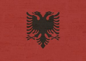 Protesters gather in a city square in Albania, holding signs and chanting against the proposed .6 billion luxury resort backed by Jared Kushner and Donald Trump.