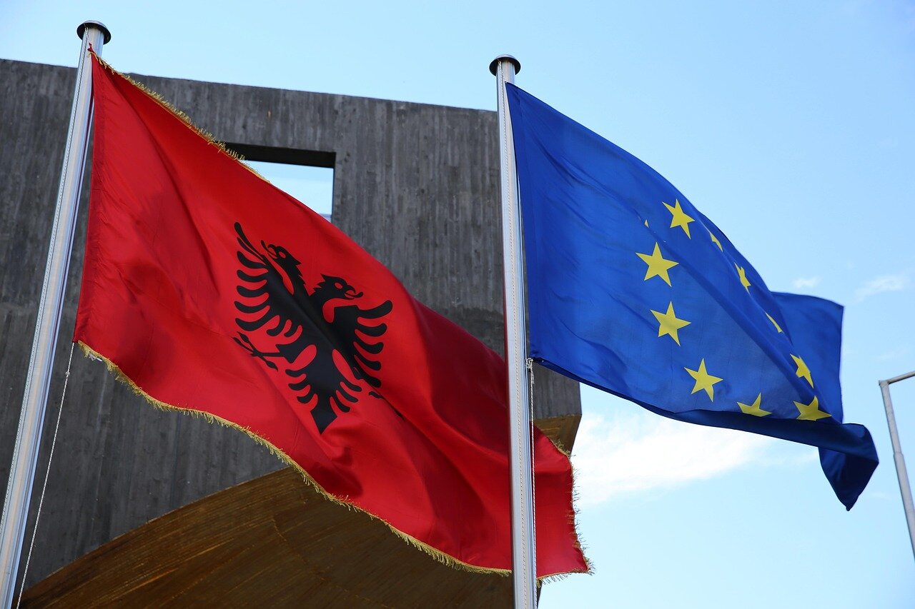 A serene view of the Albanian landscape, juxtaposed with concerns about how a luxury resort could disrupt the region's natural beauty and cultural heritage