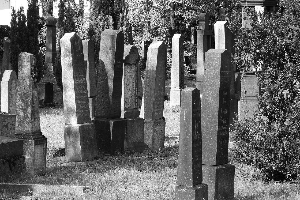 Families visit a grave adorned with traditional plastic decorations, highlighting the emotional challenges posed by potential new regulations on memorial items