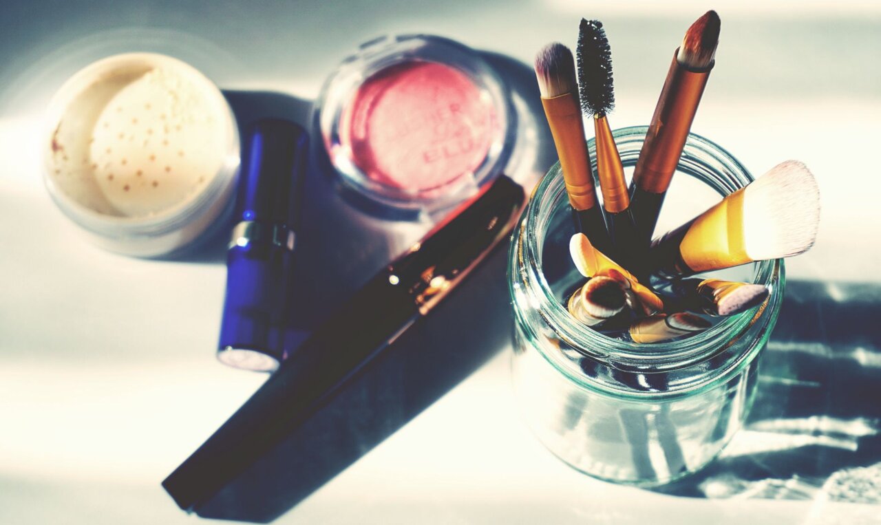 A group of young girls gathers in a brightly lit room, each focused on applying various skincare products while discussing their favorite routines and beauty tips.