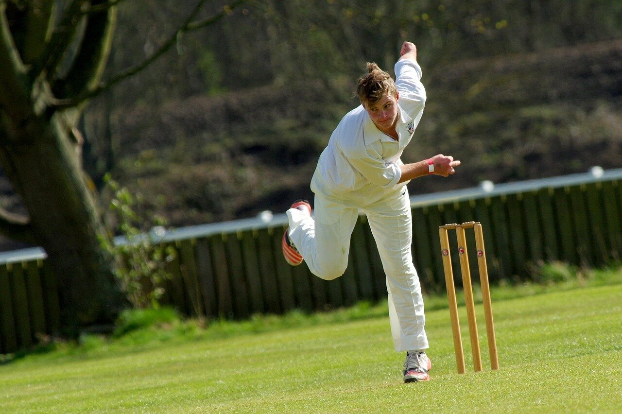 Ben Stokes stands on the cricket field, focused and determined, as he prepares to face a delivery during a tense match, with fans cheering in the background.