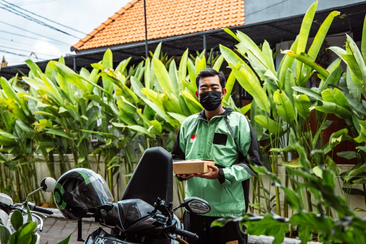 Supporters of Gojek gather outside the Jakarta District Court, holding signs and banners in response to the sentencing of the company's founder for corruption.