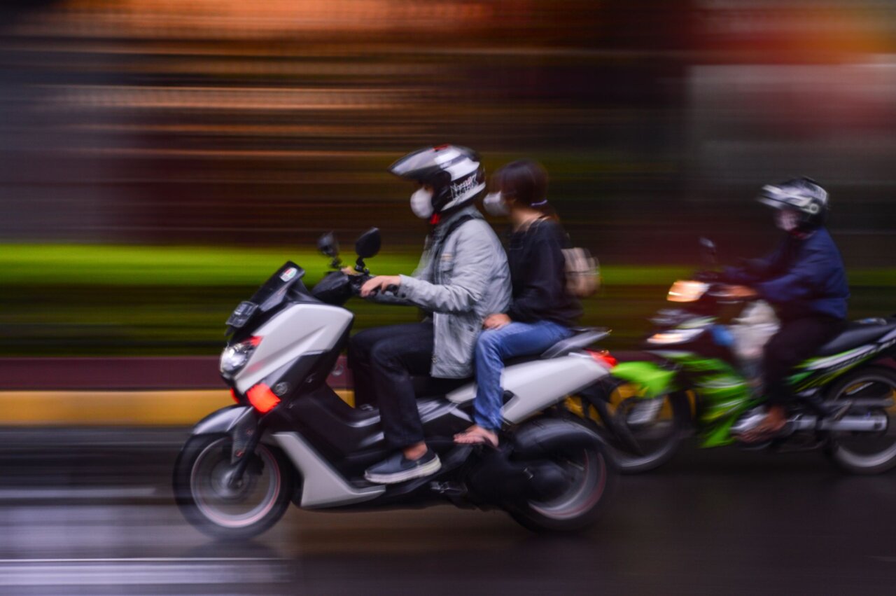 A group of concerned employees discussing the implications of the founder's sentencing on their future at Gojek