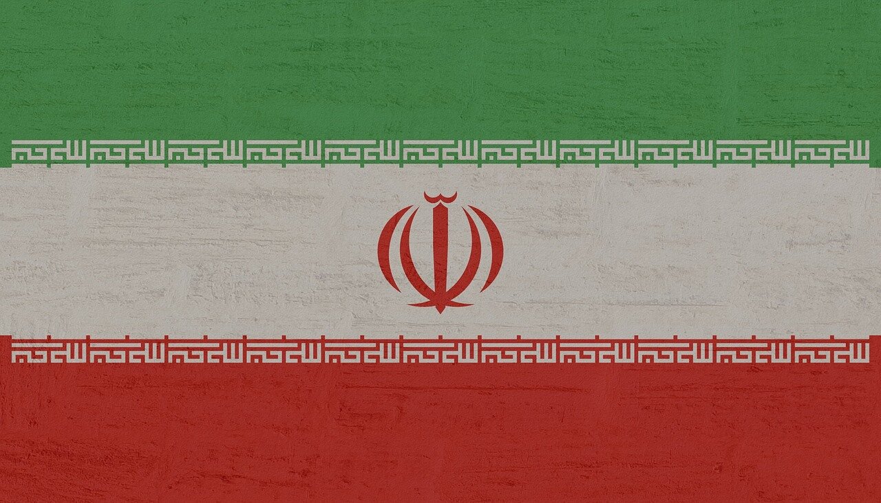 Protesters gather in Tehran, holding signs demanding economic reforms and political freedom amid rising tensions over Iran's nuclear program and international relations.