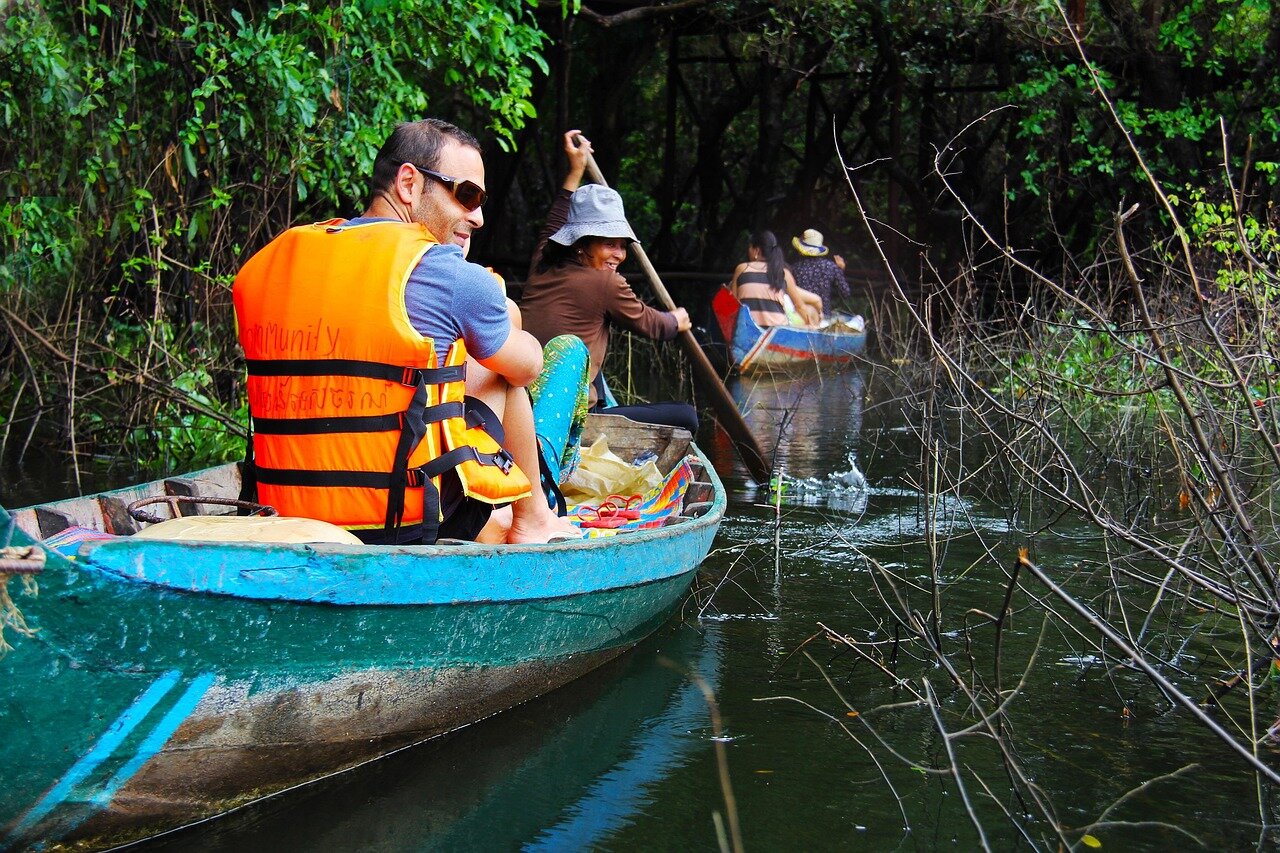 A lush mangrove forest with vibrant green foliage and intertwined roots is seen thriving along a coastline, showcasing signs of recovery from previous environmental damage.