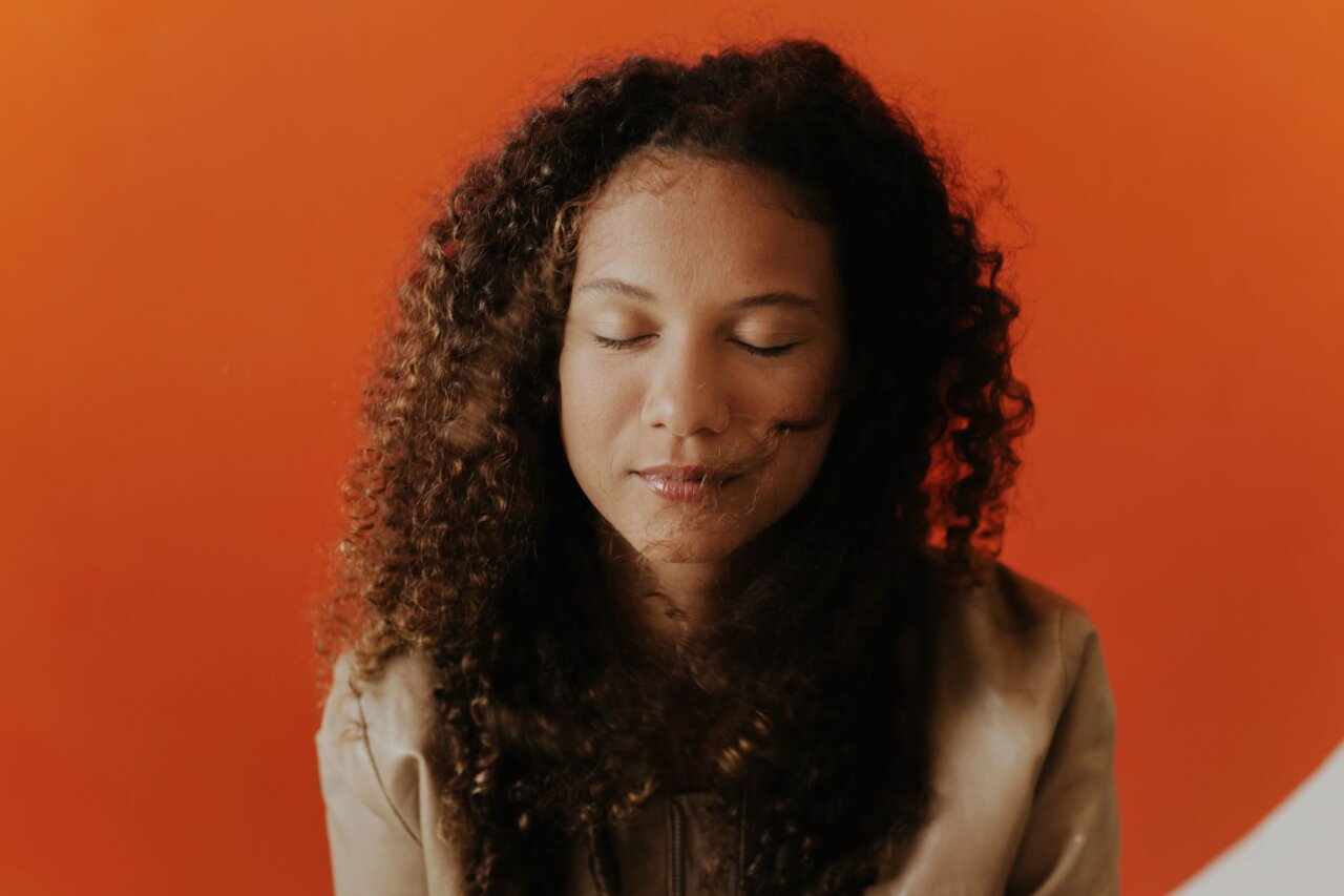 Rhiannon Giddens speaks passionately during an interview about her upcoming album, surrounded by musical instruments and notes that reflect her artistic journey.