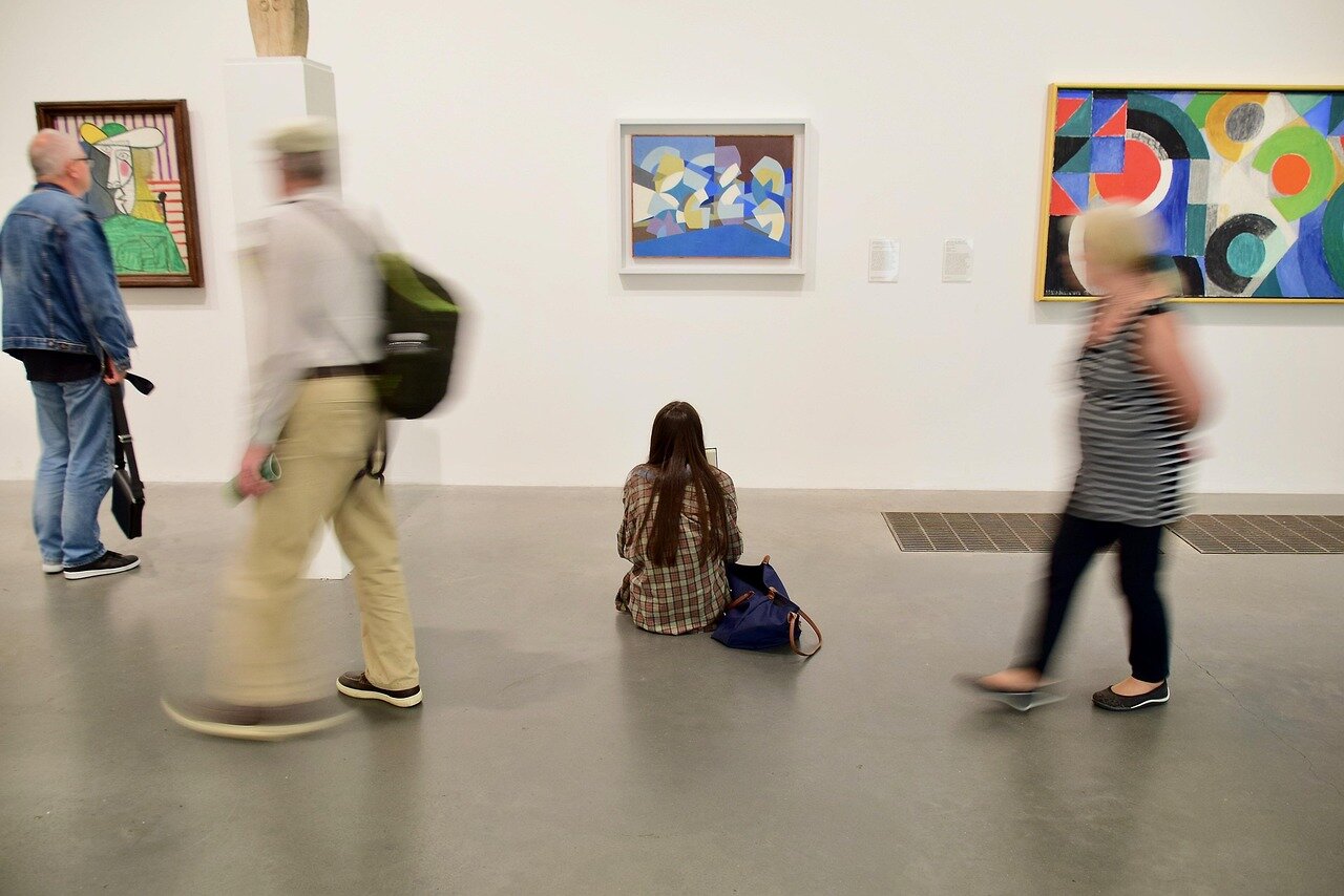 Inside the exhibition, visitors admire a stunning display of Frida Kahlo's iconic paintings and personal artifacts, captivated by her artistic legacy