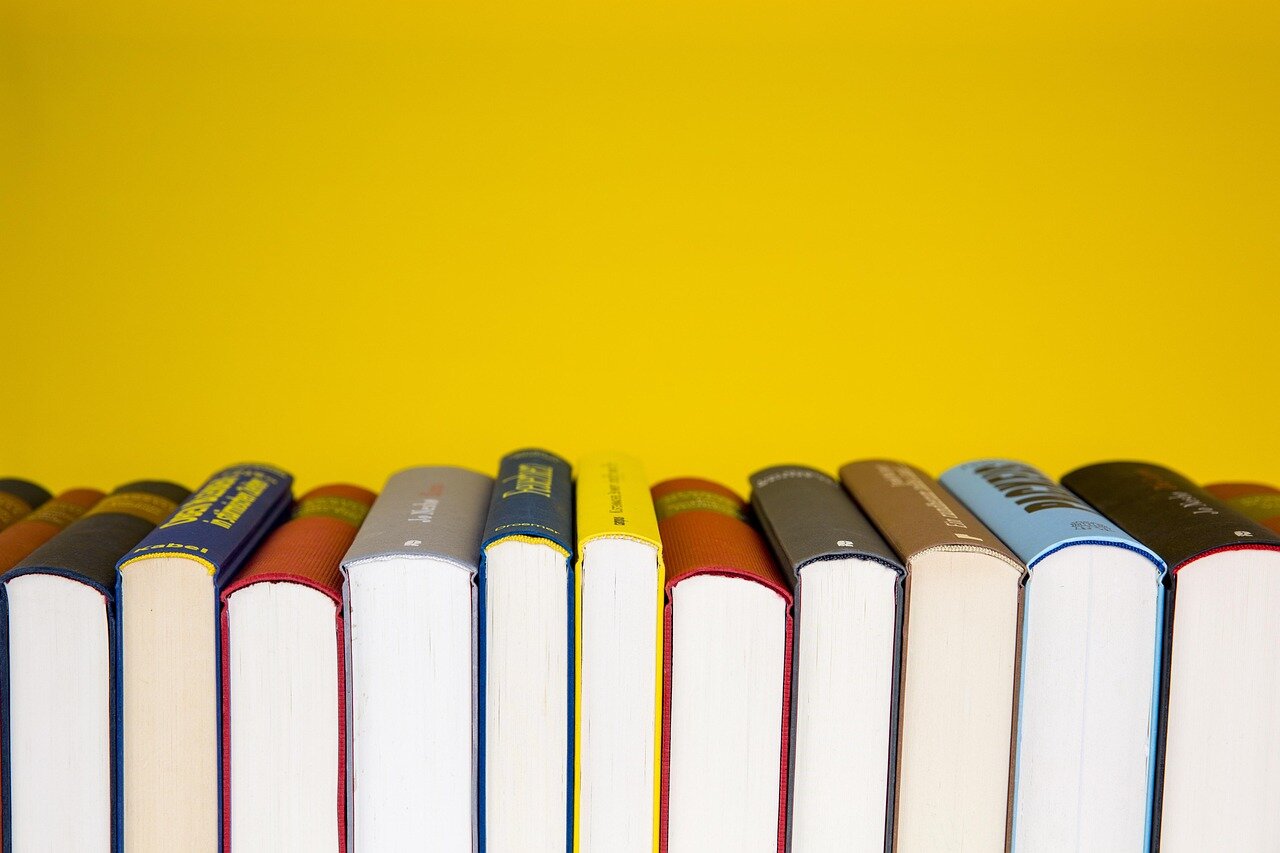 A colorful array of popular book covers displayed on a table, showcasing the diverse genres that captured readers' attention throughout June