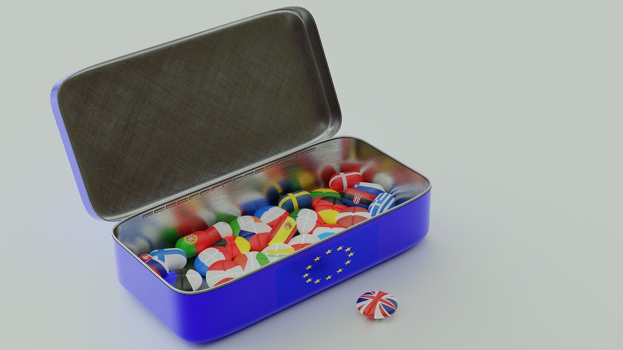 A group of people sits around a table, engaged in a lively discussion about the implications of Brexit, with notes and cups of coffee scattered in front of them.