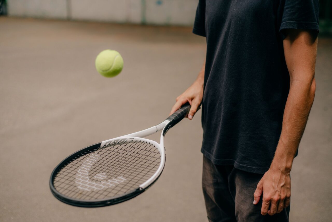 Novak Djokovic celebrates his victory over Stefanos Tsitsipas after winning their match at Wimbledon, showcasing his signature fist pump while surrounded by cheering fans.