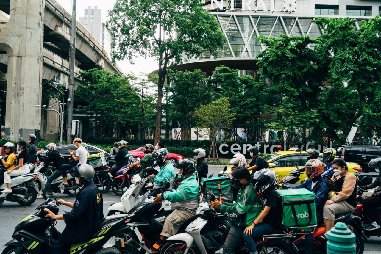 A group of investors gathered in a conference room, discussing the implications of the recent corruption case involving Gojek's founder