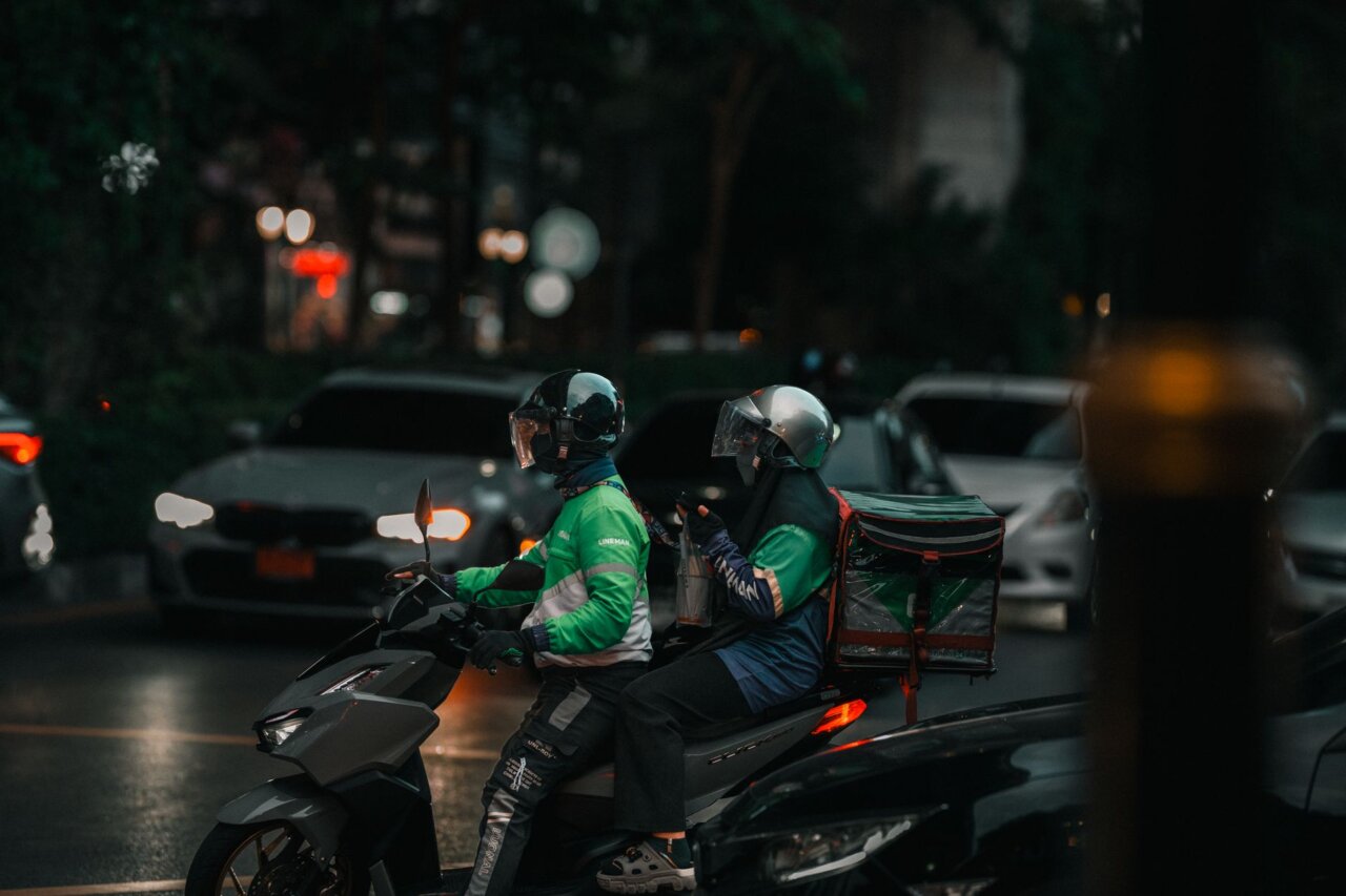 A busy Gojek service center where customers are using the app for food delivery and ridehailing, showcasing the company's impact on daily life