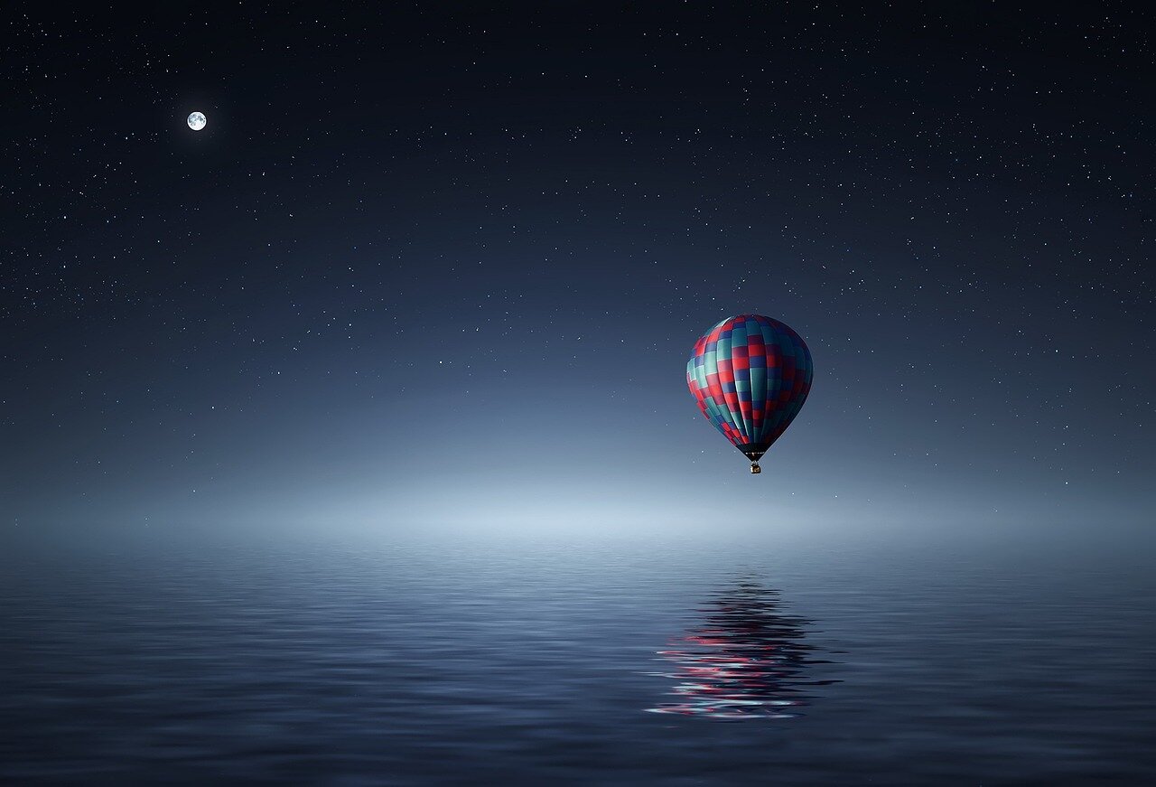 A group of people gathered in a dark location, enjoying the breathtaking view of the supermoon and twinkling stars above