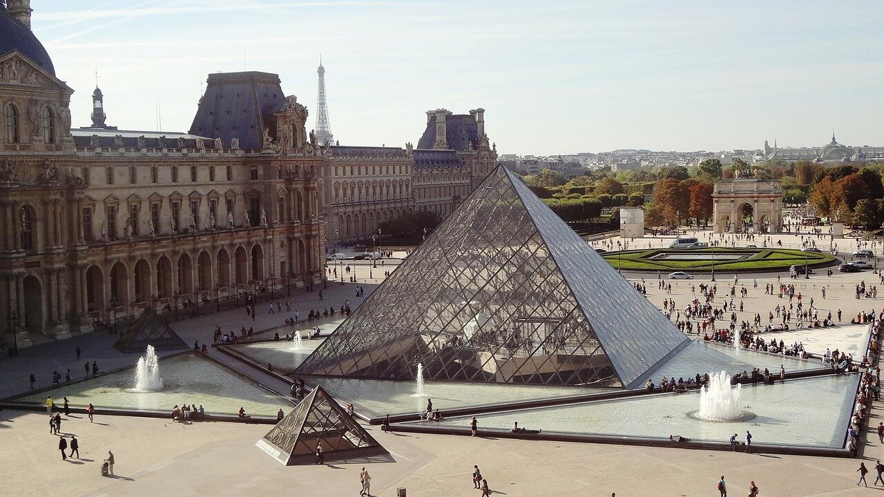 A bustling crowd gathers outside a large venue in Paris, eagerly waiting to enter the Esports World Cup, with banners and promotional displays highlighting the event's significance in the gaming industry.