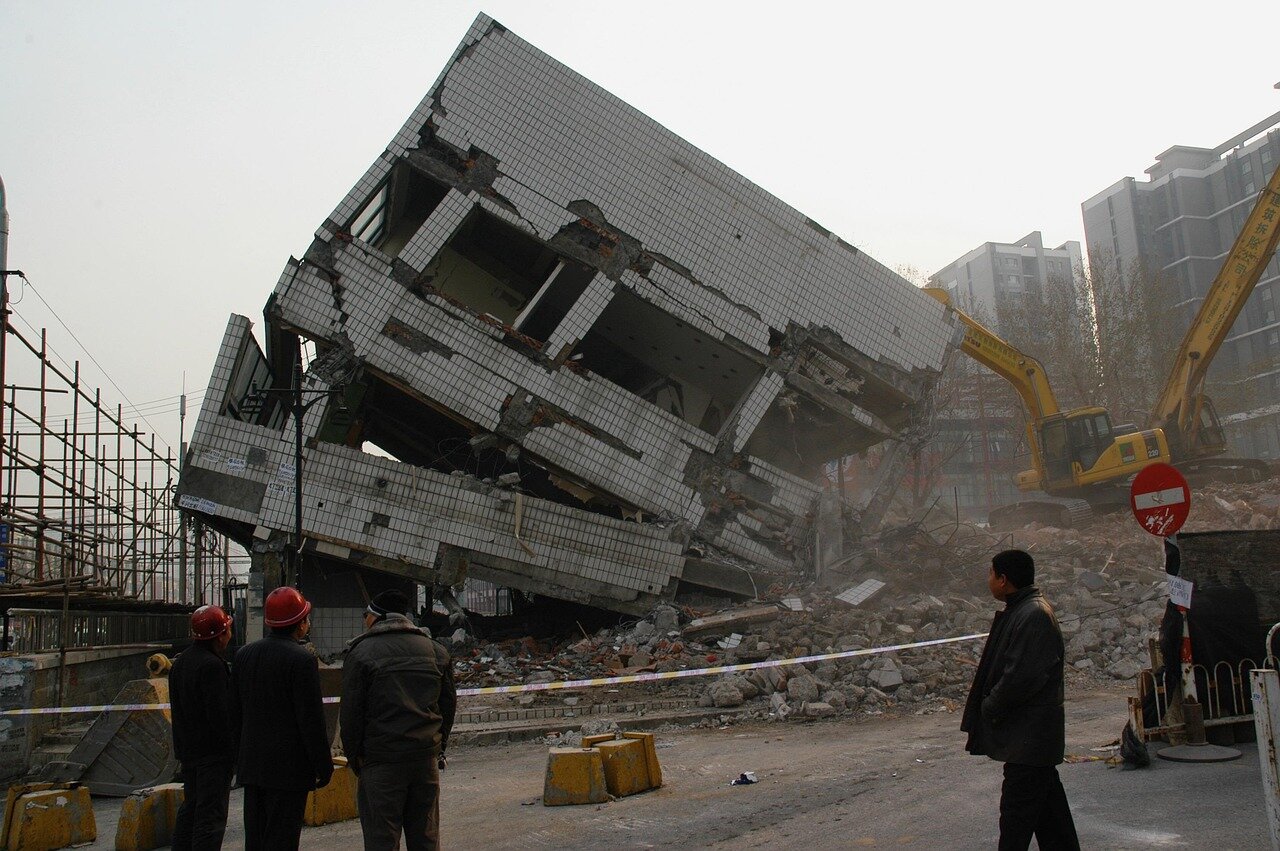 Onlookers cheer and applaud, expressing their relief and joy at the sight of the guard being rescued from the collapsed structure