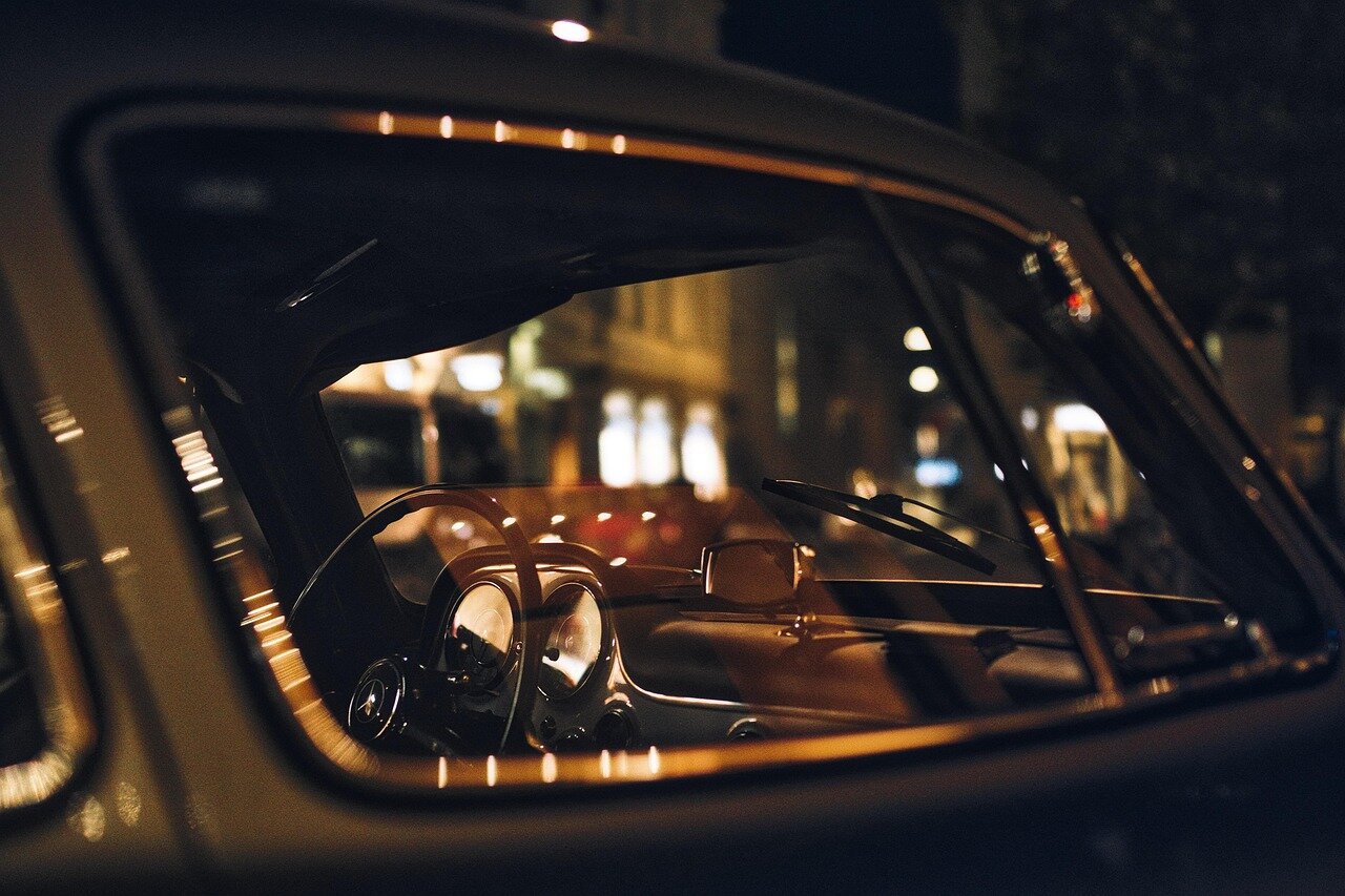 A car owner looking concerned while reviewing insurance policy documents, reflecting the anxiety and economic implications of vehicle theft in the context of connected car technologies
